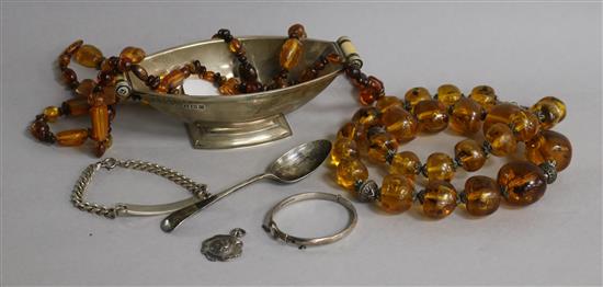 An Art Deco silver bowl, spoon, bracelet, bangle and medallion and two amber necklaces